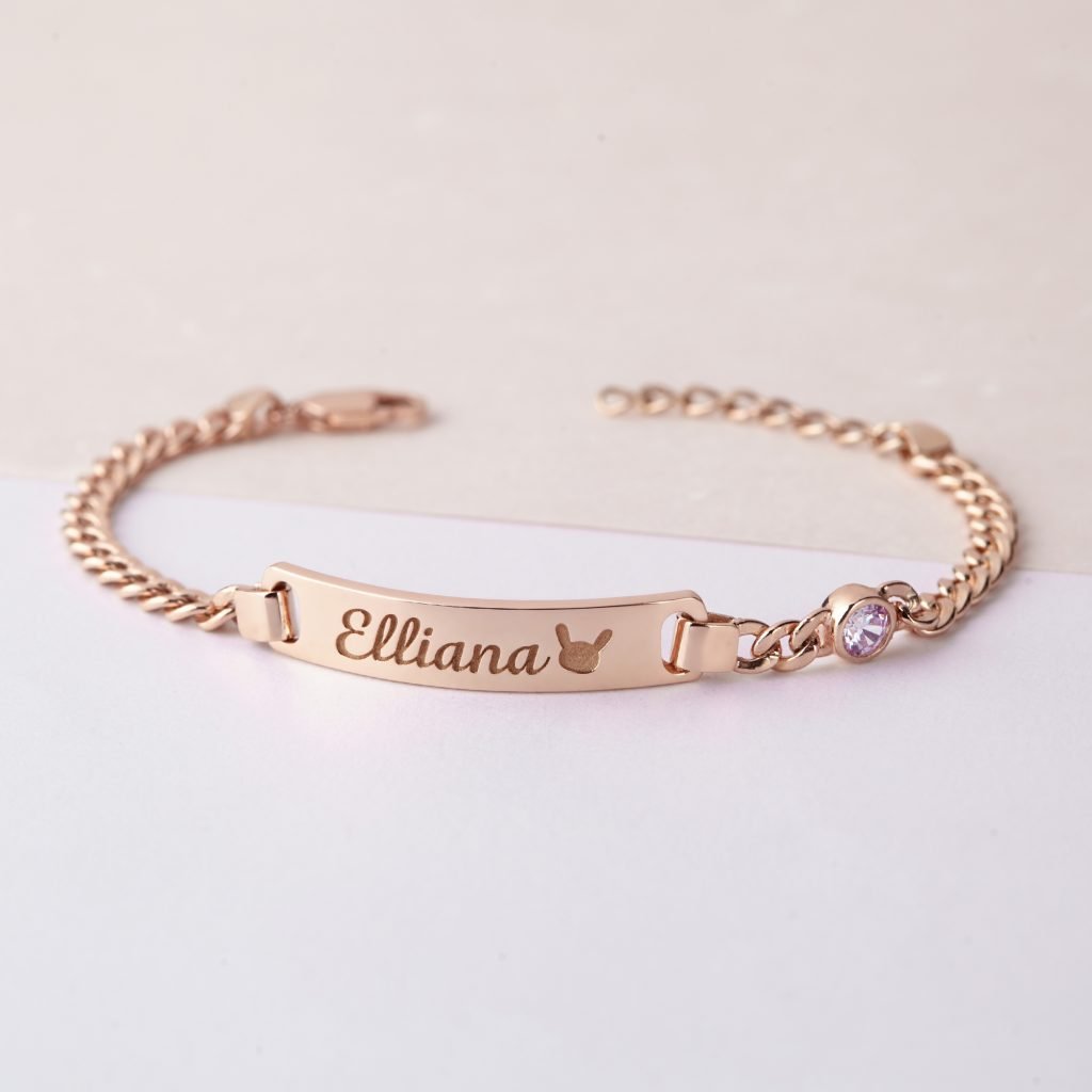 img src="bracelet.png" alt="bracelet with kid's name and a bunny icon engraved in rose gold color"