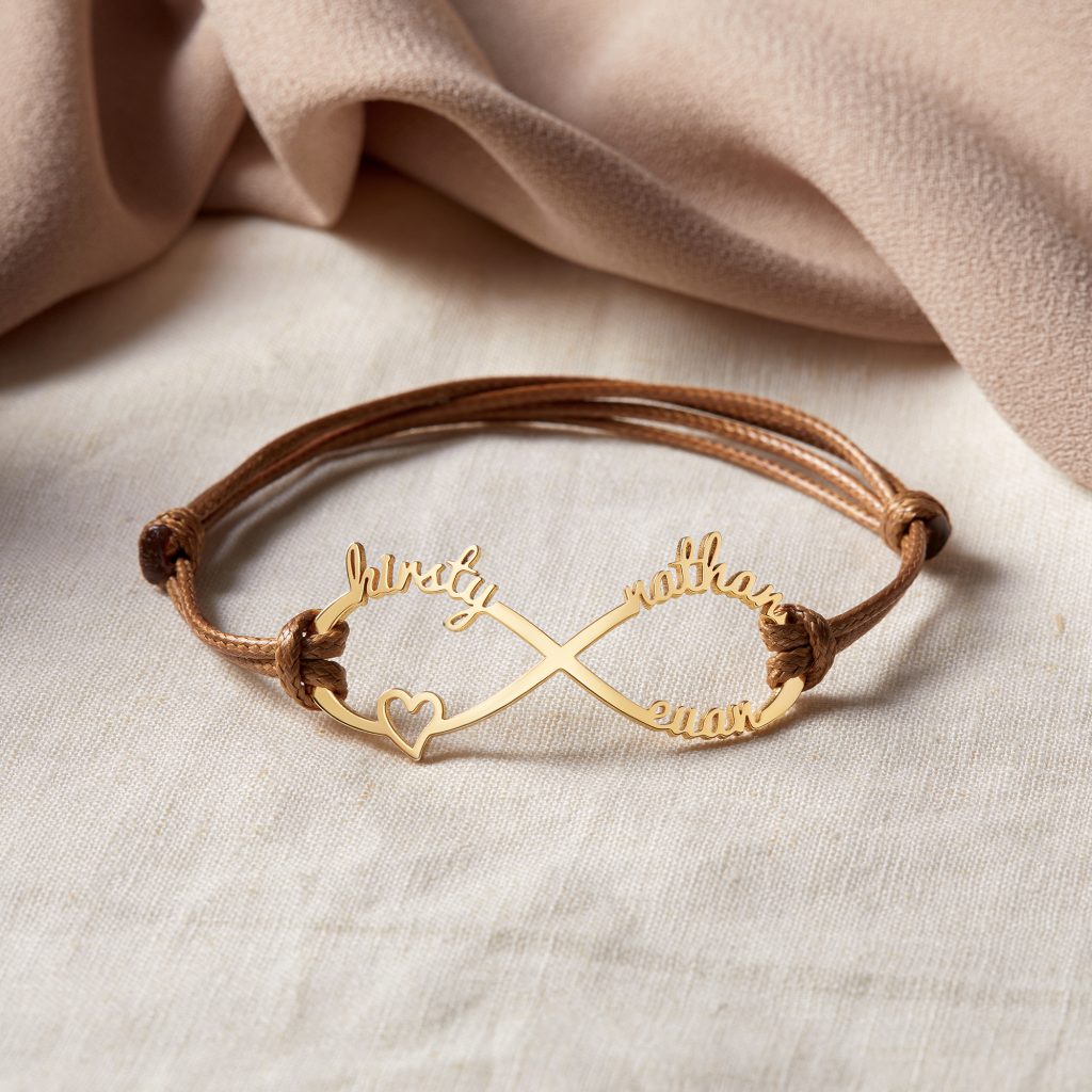 img src="bracelet.png" alt=" brown leather bracelet with kids' names engraved in yellow gold color"